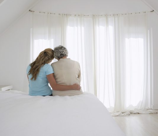 Mother and Daughter Sitting on Bed