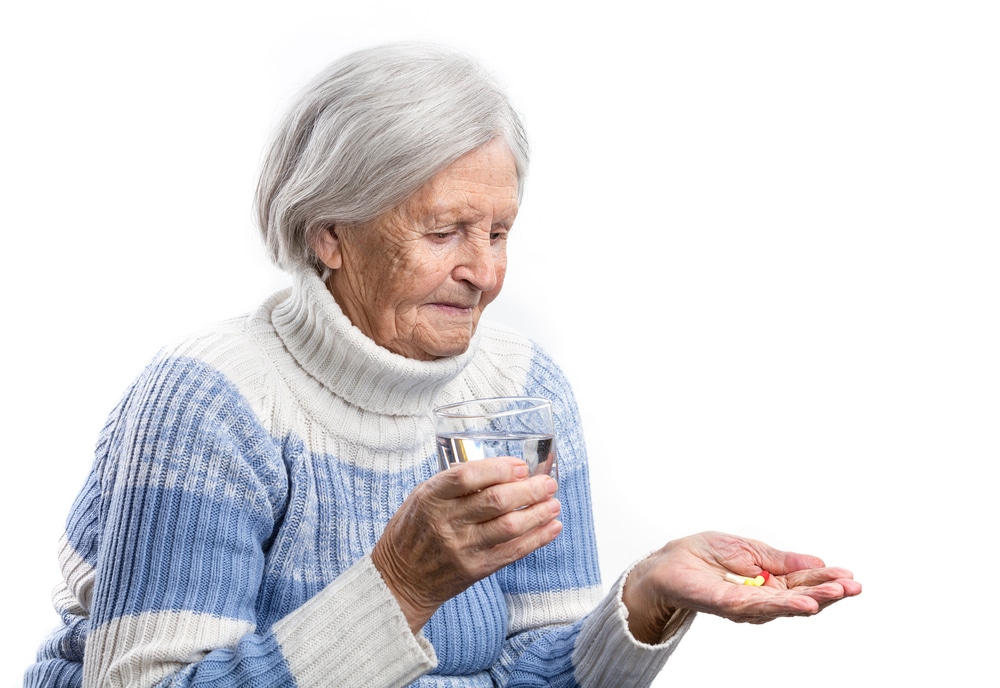Old lady taking tablet