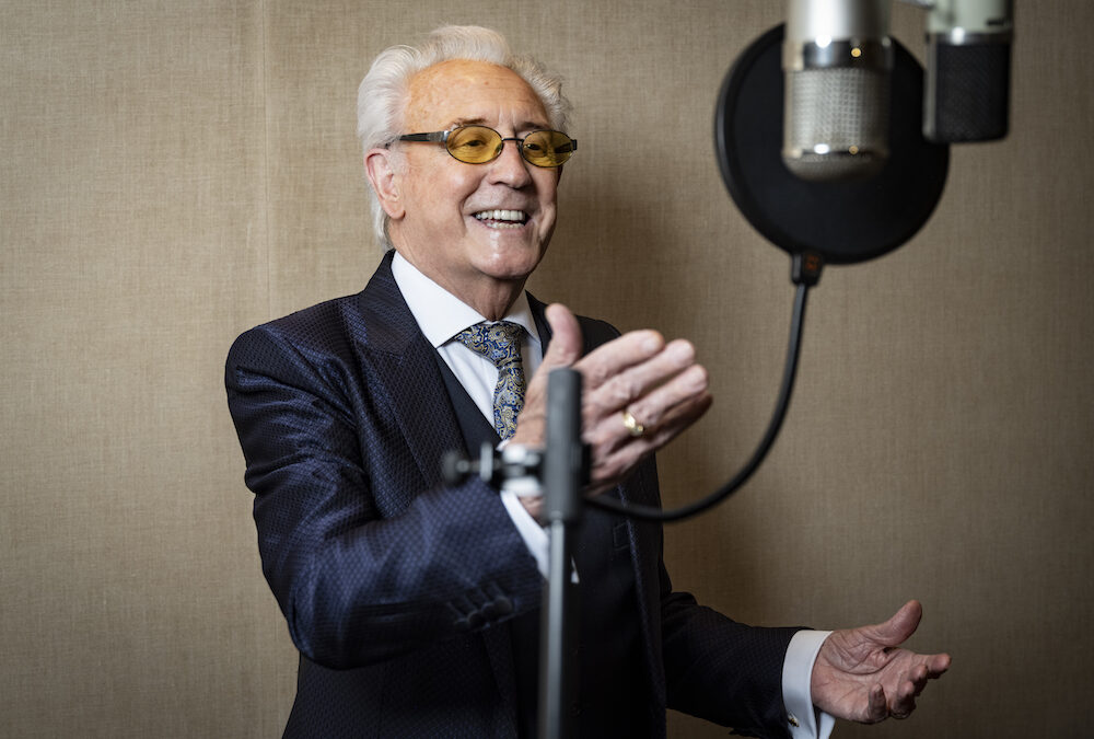 Singer Tony Christie at a microphone